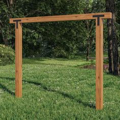 a wooden frame sitting on top of a lush green field