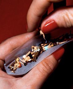 a woman is holding a knife with several small objects in it's blades and the blade has been cut into smaller pieces