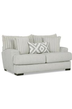 a white couch with pillows on it and a pillow in the middle of the couch