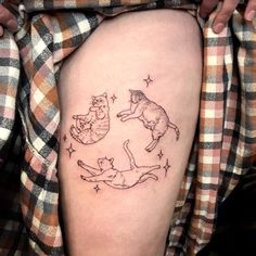 a woman's thigh with three cats on it and stars in the sky above her