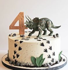 a birthday cake with a dinosaur and number four on it