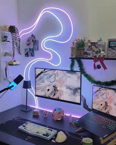 a desk with two computer monitors and a laptop on it, in front of a neon wall