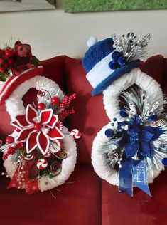 three christmas wreaths sitting on top of a red couch