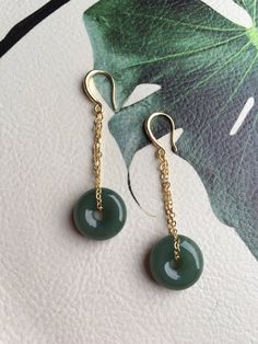 A gorgeous pair of dark green jade donut earrings. The royal style long dangles gold earrings, paired with the vintage green jade circles are eye-catching and elegant. Hade made with high-quality materials only and comes in the gift-worthy package, perfect as a gift for yourself or your loved ones. Some highlights of this pair of breath-taking natural green jade drop earrings are: *High-quality guaranteed Hand made with grade-A natural dark green jade. The chain is gold plated, ensure long lasti Jade Dangle Earrings For Pierced Ears, Handmade Dark Green Round Jewelry, Elegant Green Circular Earrings, Handmade Jade Drop Earrings Jewelry, Jade Earrings Drop, Dark Green Round Jade Jewelry, Pierced Jade Dangle Earrings, Hypoallergenic Dangle Jade Earrings, Hypoallergenic Jade Dangle Earrings