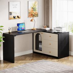 a desk with a laptop on it in front of a window and potted plant