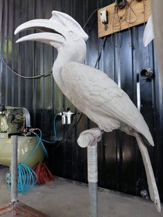 a large white bird sitting on top of a metal pole