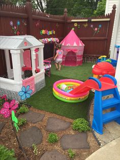 an outdoor play area with children's toys in the back yard and on the lawn