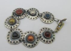 Awesome sterling silver bracelet with a modernist industrial look. I believe the bracelet is artisan (hand) made and each disc has each a different material: lapis lazuli, red jasper, copper, brass, onyx heart and amber (amber tested with UV light). Very unique and elegant. Statement piece. Some patina on it. Marked AS. Tested as sterling silver. Measurements: approx. 7.7 inches long & approx.0.9 inches in diameter Please note that due to lighting effects, monitor's brightness, contrast and othe Disc Bracelet, Work Jewelry, Funky Jewelry, Red Jasper, Uv Light, Sterling Silver Bracelet, Chain Link Bracelet, Sterling Silber, Sterling Silver Bracelets