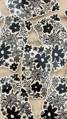 black and white paper cut outs with flowers on them are sitting on a tablecloth