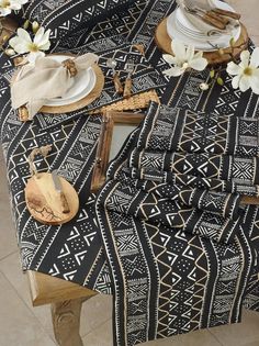 the table is covered with black and white cloths, plates and utensils