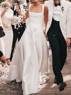 a bride and groom walk down the aisle as confetti is thrown around them