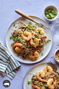 two plates with noodles and shrimp on them next to bowls of peas, broccoli and rice