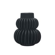 a black vase sitting on top of a white surface