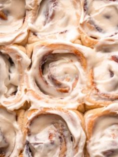 an assortment of pastries sitting on top of a pan covered in frosted icing