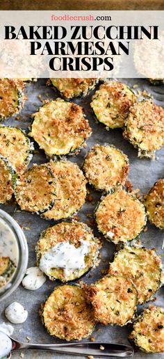 baked zucchini parmesan crispes on a baking sheet with dipping sauce