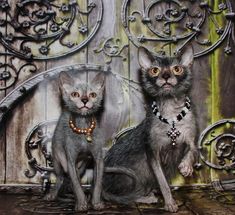 two cats sitting next to each other in front of a wooden wall with ornate carvings