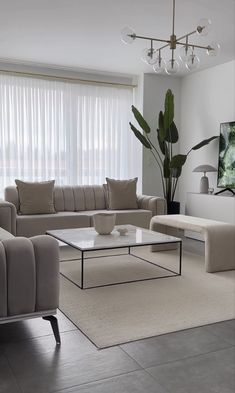 a living room with couches, chairs and a coffee table in front of a window