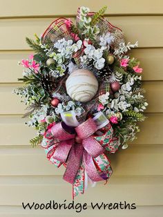 a wreath hanging on the side of a house with words woodbridge wreaths written below it