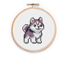 a cross stitch dog is shown in the hoop with an embroidery pattern on it's side