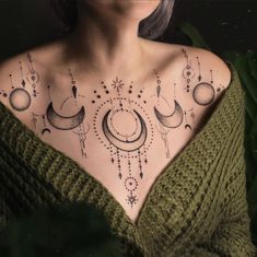 a woman's chest with tattoos on it, and the moon in the sky