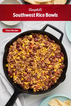 a skillet filled with chili and corn next to tortilla chips