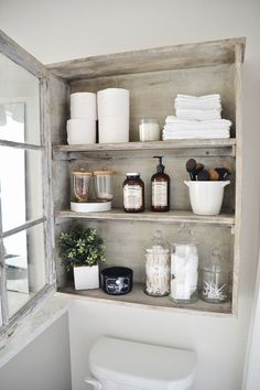 the shelves in this bathroom are filled with toilet paper, soaps and other items