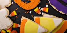 decorated cookies and candy on a table with halloween decorations around the edges, including jack - o'- lanterns