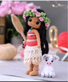 a crocheted doll and small stuffed animal next to each other on a table