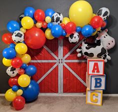 a bunch of balloons that are in front of a door with a cow on it