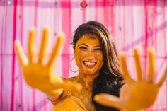 a woman with yellow paint on her face and hands