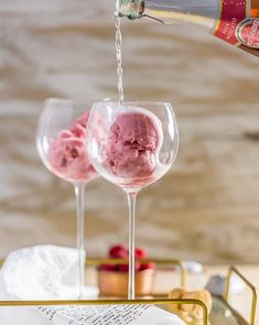 two wine glasses with ice cream being poured into them