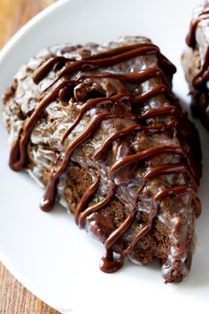 two pieces of chocolate cake on a white plate with drizzled icing