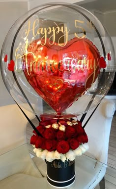 a heart - shaped balloon with roses in it and the words happy 50th written on it