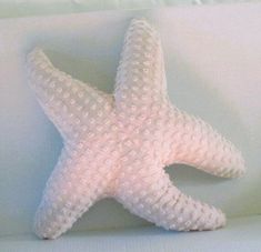 a white knitted starfish sitting on top of a bed