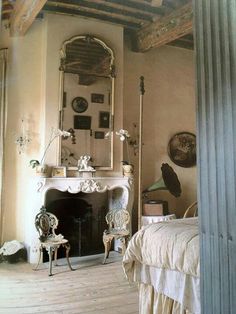 an old fashioned bedroom with a fireplace and mirror