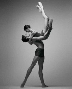 two people in leotards are doing ballet moves with their arms around each other