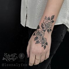 a woman's hand with a flower tattoo on it