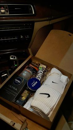 an open box containing socks and other items in a car's dash board area