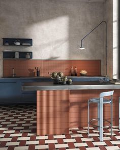 an orange and white tiled kitchen with two stools in front of the counter top