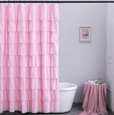 a pink shower curtain in a bathroom next to a toilet