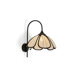 a wall light that is on the side of a white wall with a flower shaped glass shade