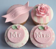 four cupcakes decorated with pink and white frosting