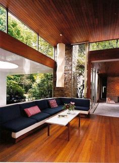 a living room filled with furniture and lots of wood on top of a hard wood floor