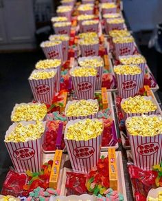 rows of popcorn boxes filled with candy and candies on a table in a restaurant