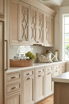 a kitchen filled with lots of wooden cabinets and white counter top space next to a window