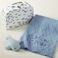 a blue towel with a fish on it next to a white box