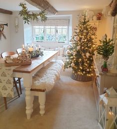 a dining room with a christmas tree in the corner and other decorations on the table