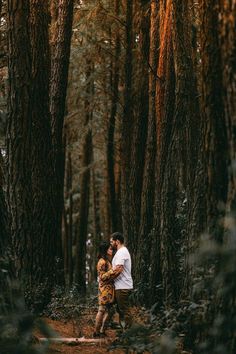 an engaged couple walking through the woods together