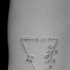 a small triangle tattoo on the side of a woman's thigh