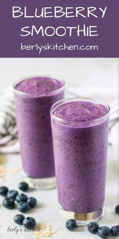 two glasses filled with blueberry smoothie on top of a table